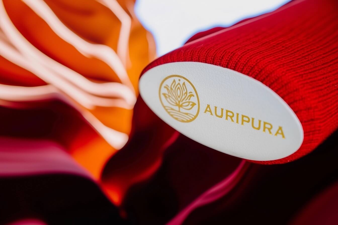 Auripura Energiestab für das Wurzelchakra ragt schräg von rechts oben ins Bild, roter Schimmer im Fokus.